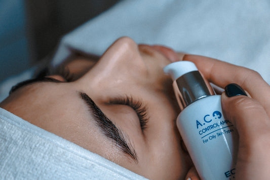 a woman laying down with her eyes closed and a bottle of eye cream on her