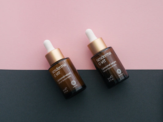 two bottles of the same product on a pink and black background