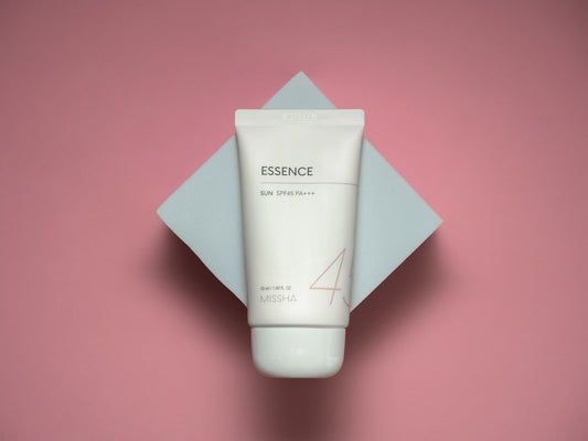 a tube of cream sitting on top of a pink surface