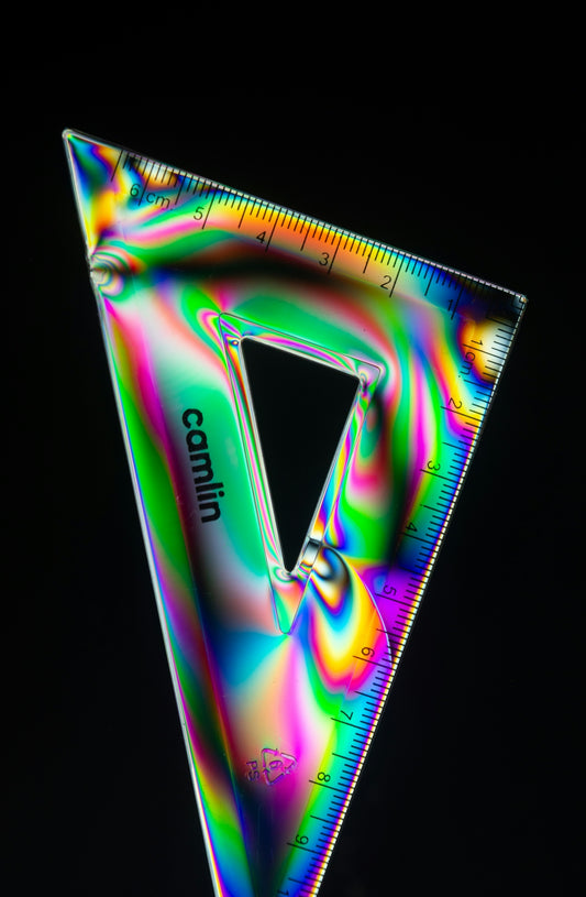 A triangular ruler with colorful light patterns
